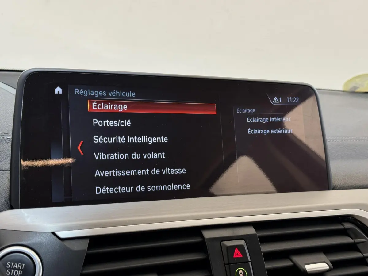 Écran tactile du système de navigation BMW X3 xDrive30d 2018 affichant les réglages véhicule, vue intérieure frontale.