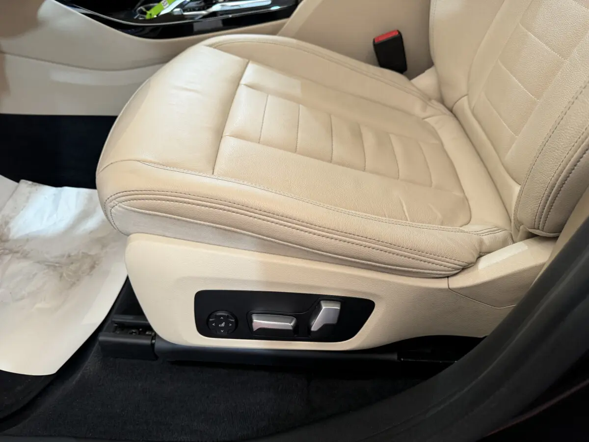 Gros plan sur le siège avant gauche en cuir beige clair d'une BMW X3 xDrive30d 2018, avec commandes électriques visibles.