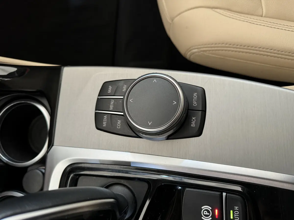 Gros plan sur la molette de commande iDrive et console centrale en aluminium brossé du BMW X3 gris foncé 2018 Luxury.