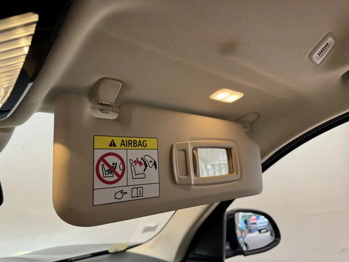 Détail du pare-soleil beige avec miroir éclairé côté conducteur d’un BMW X3 gris foncé 2018.