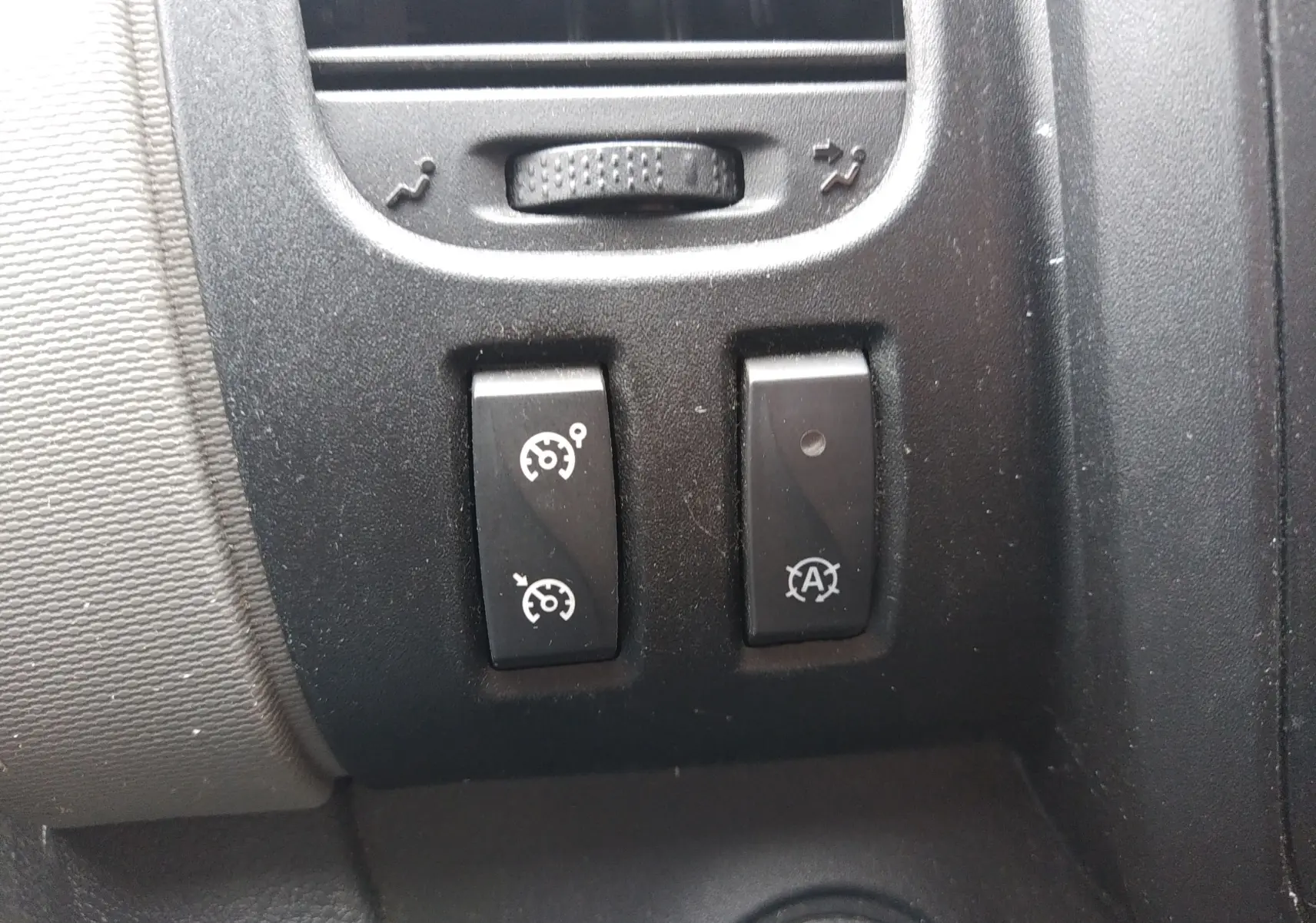 Gros plan sur les commandes de régulateur de vitesse et arrêt automatique du moteur du Renault Trafic Microbus blanc de 2016.