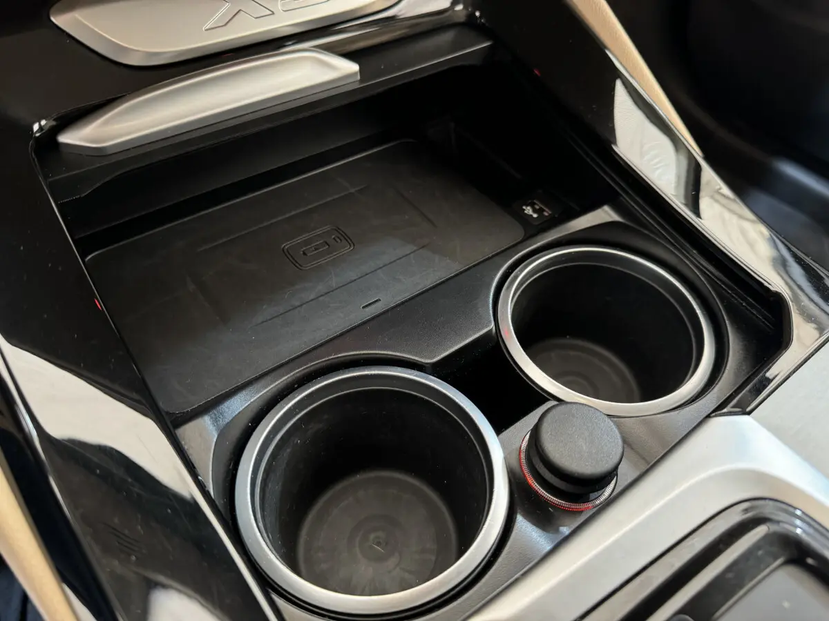 Gros plan sur la console centrale noire du BMW X3 xDrive30d 2018, avec porte-gobelets et molette de commande.