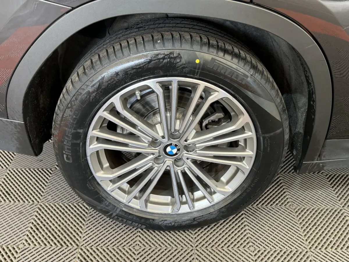 Gros plan sur la roue avant droite du BMW X3 gris foncé, mettant en valeur la jante alliage multi-branches et le pneu.