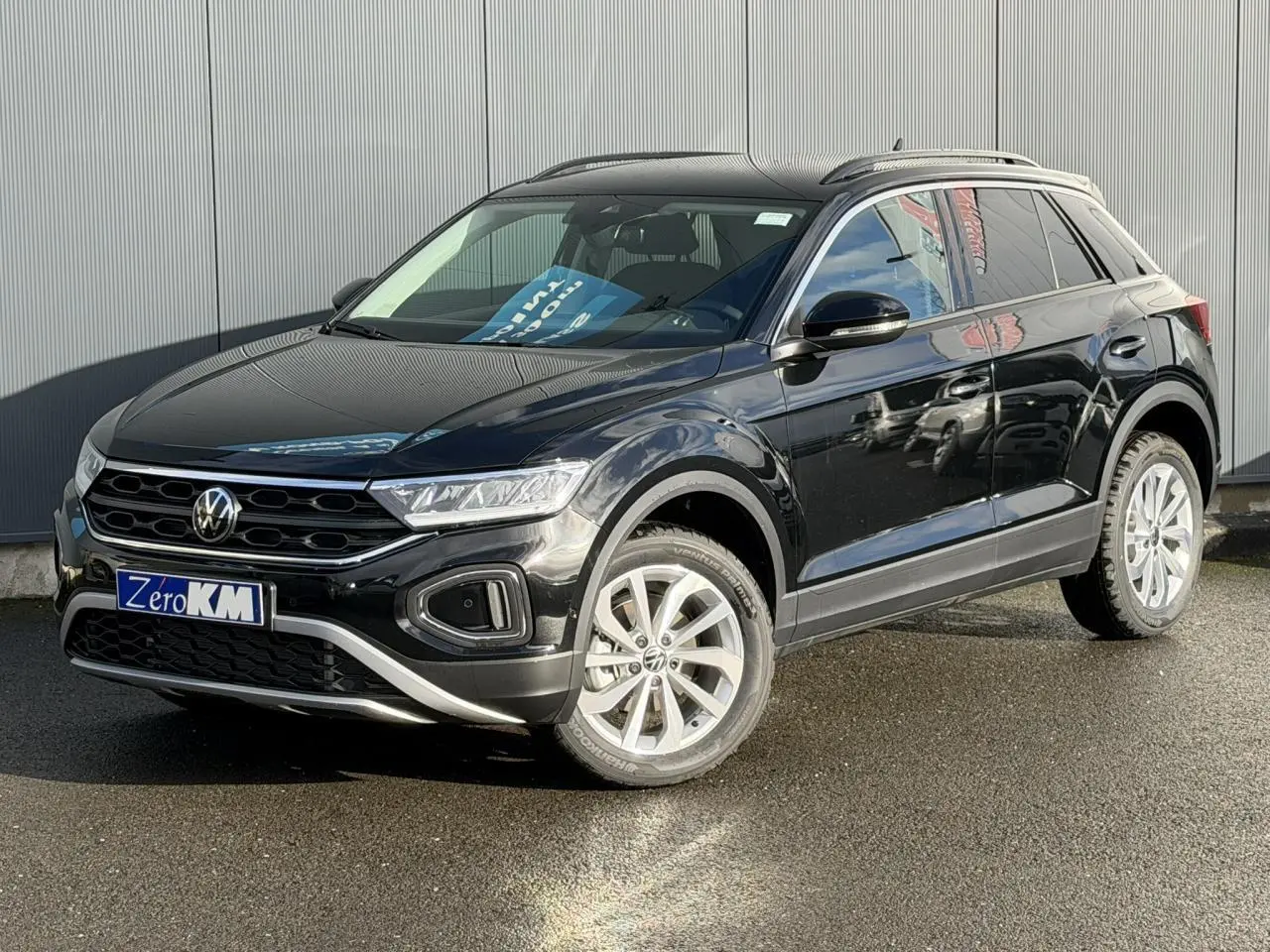 Volkswagen T-Roc Deep Black vue 3/4 avant droit, avec jantes argentées et toit ouvrant panoramique.