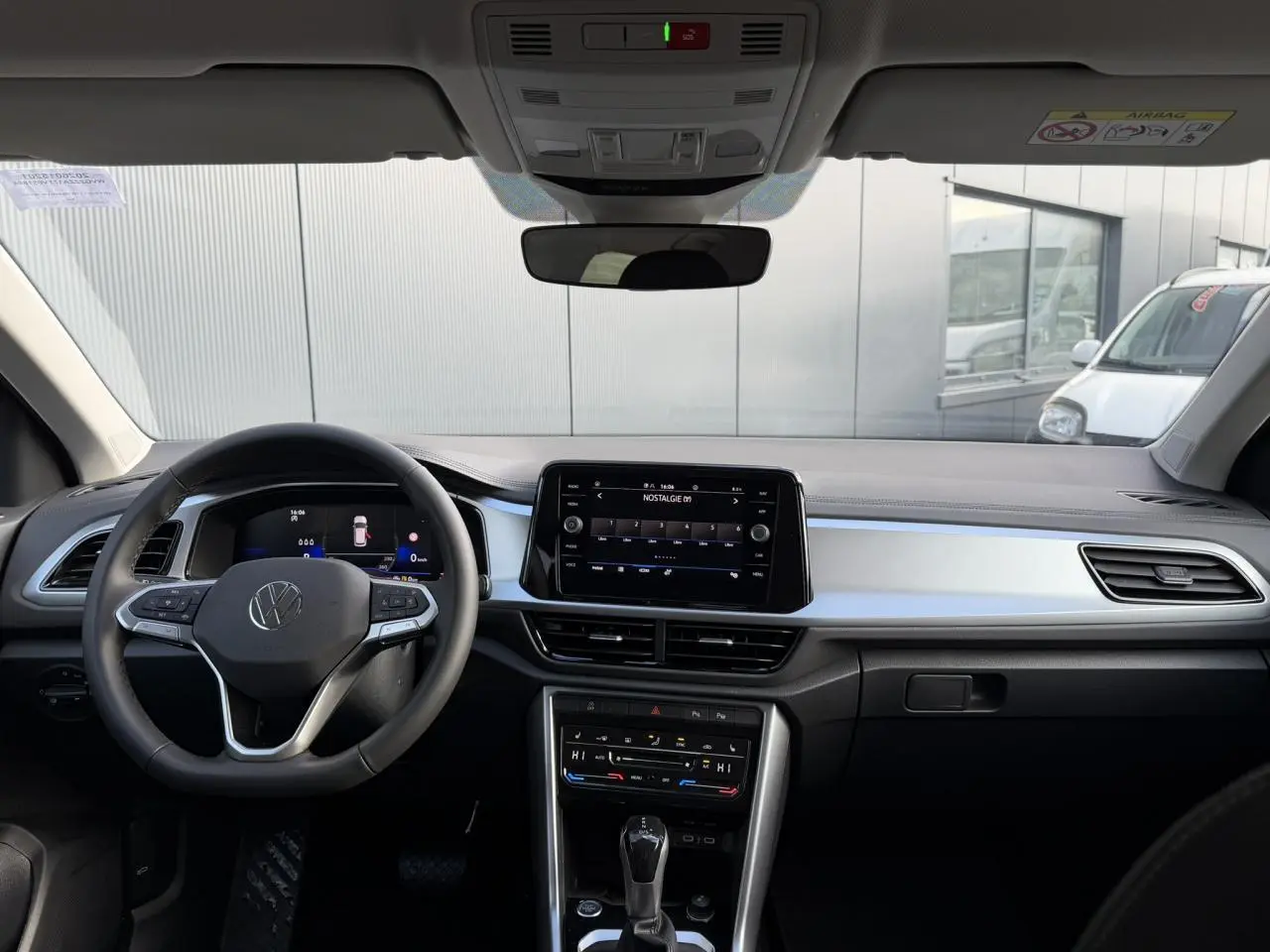 Vue intérieure avant du Volkswagen T-Roc 1.5 TSI 150 DSG Life 30 Years avec tableau de bord noir et écran tactile central.