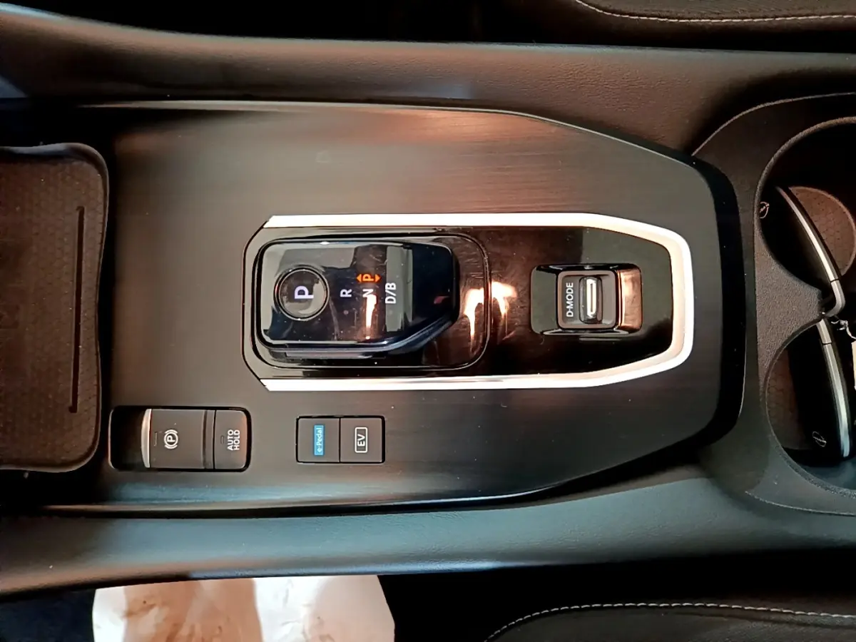 Vue plongeante sur la console centrale noire du Nissan Qashqai e-Power 2023 avec sélecteur de vitesse et boutons de mode.