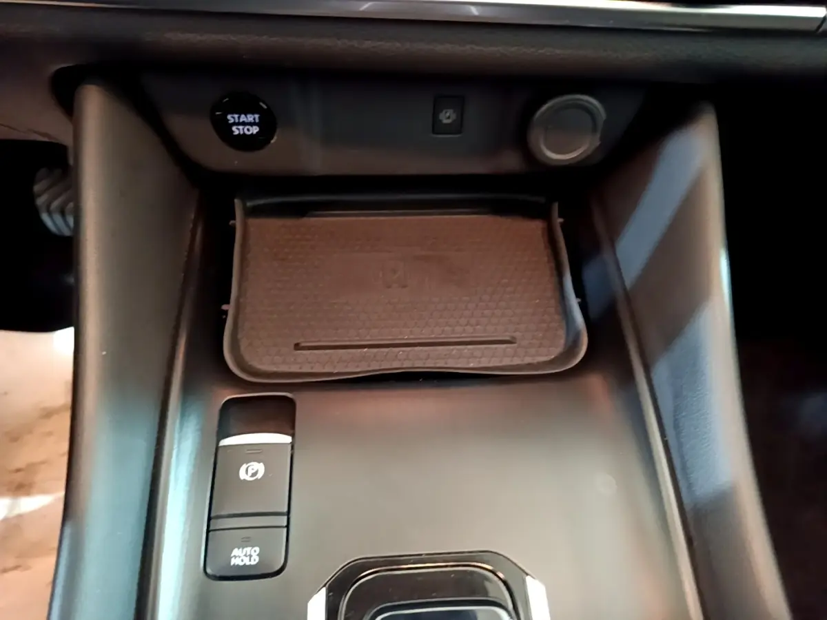 Gros plan sur la console centrale noire du Nissan Qashqai e-Power 190 N-Connecta avec bouton start/stop et frein à main électrique.