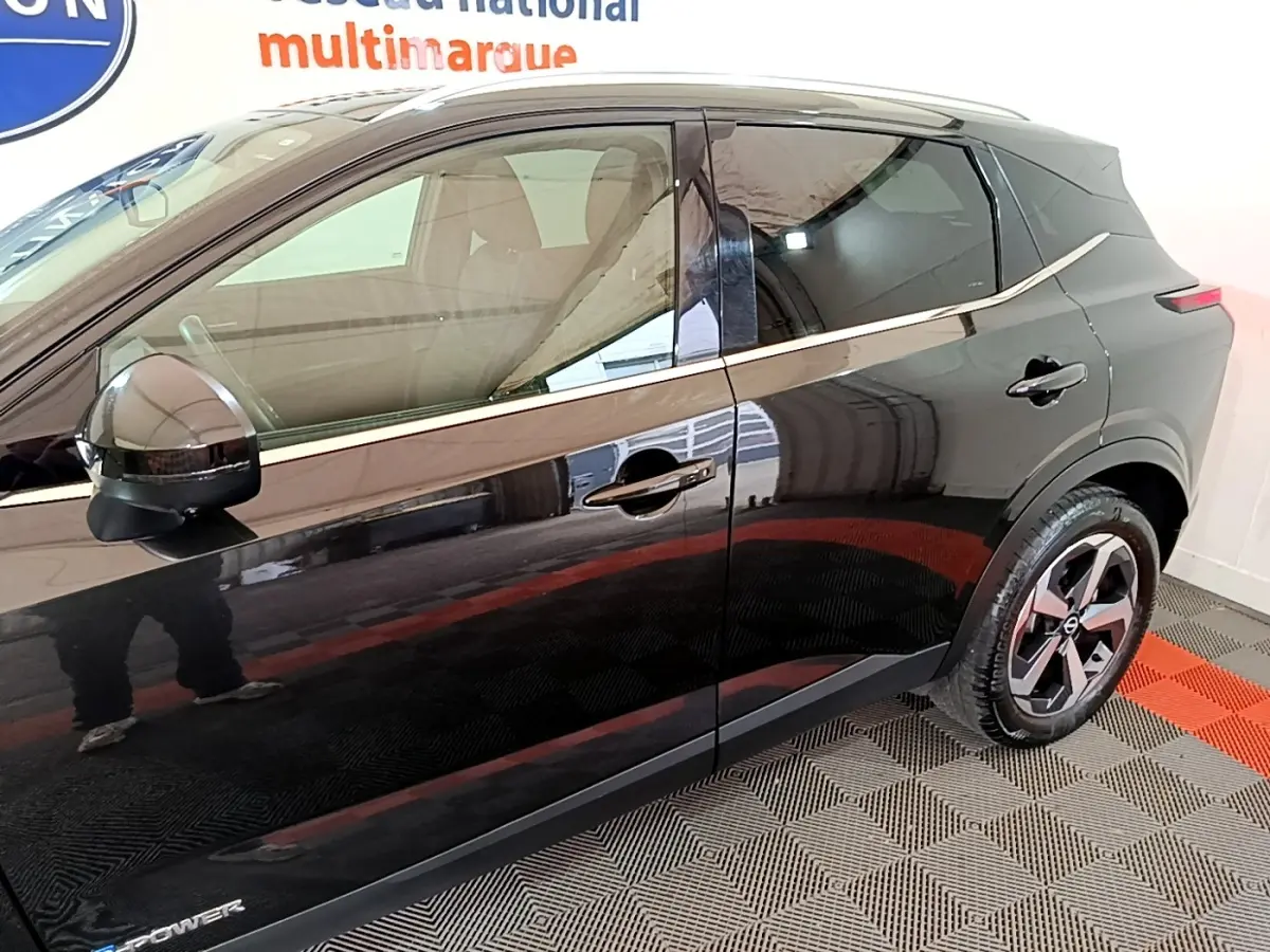 Vue de profil côté gauche du Nissan Qashqai e-Power noir, soulignant la ligne de chrome et les jantes alliage.
