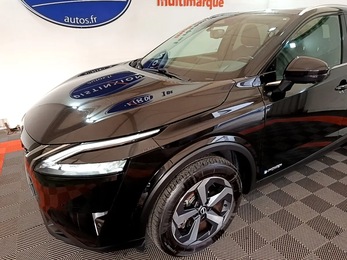 Vue 3/4 avant droit du Nissan Qashqai e-Power noir brillant avec jantes alliage et phares LED allumés.