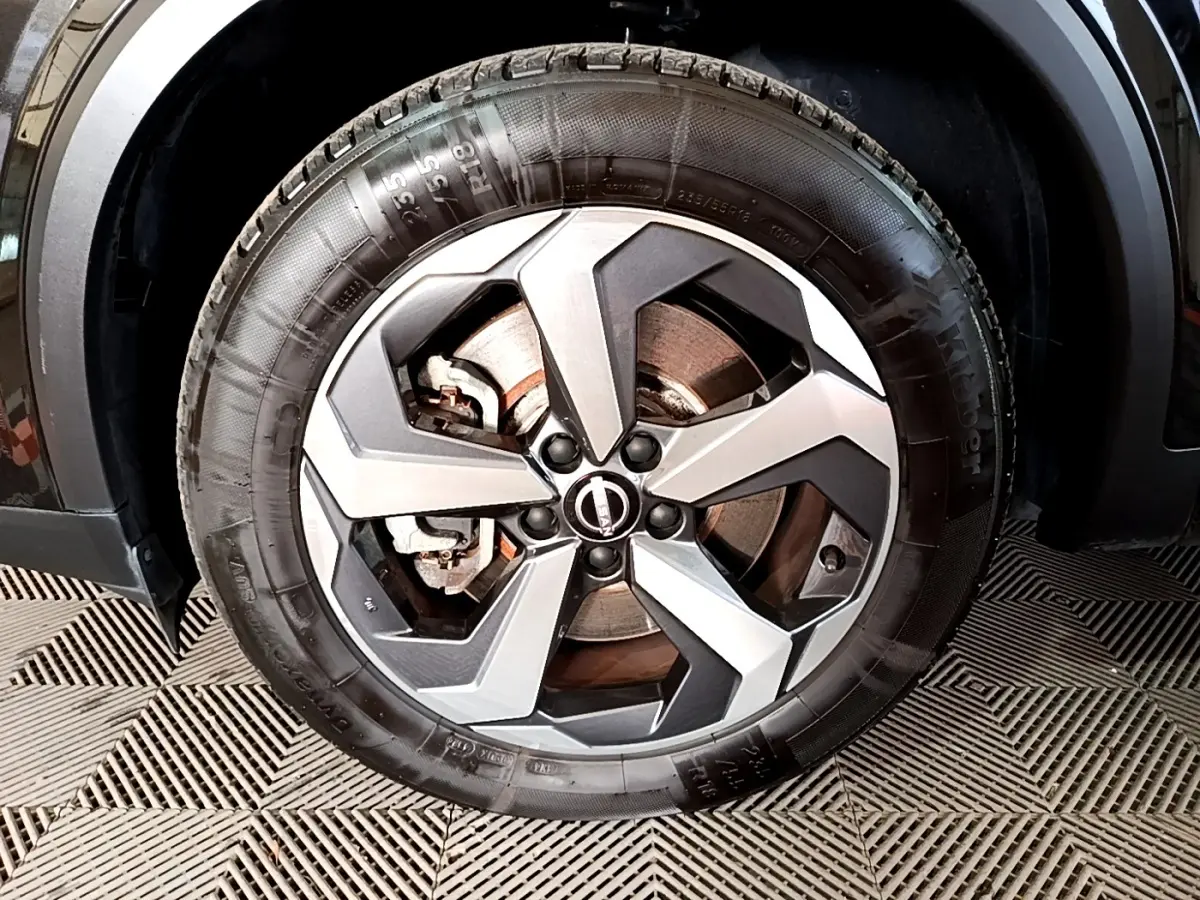 Gros plan sur la roue avant droite noire du Nissan Qashqai e-Power 190 N-Connecta avec jante alu bicolore.