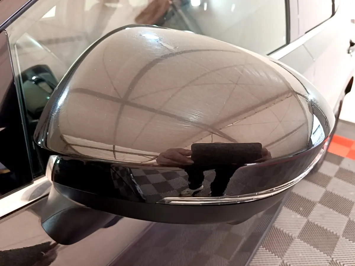 Gros plan sur le rétroviseur extérieur gauche noir brillant du Nissan Qashqai e-Power 2023 avec clignotant intégré.