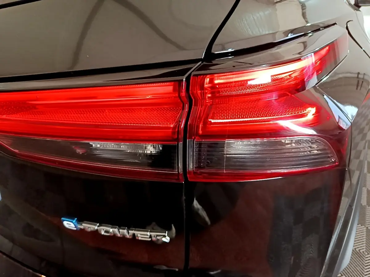 Gros plan sur le feu arrière droit rouge et blanc d’un Nissan Qashqai e-Power noir, avec logo e-Power visible.