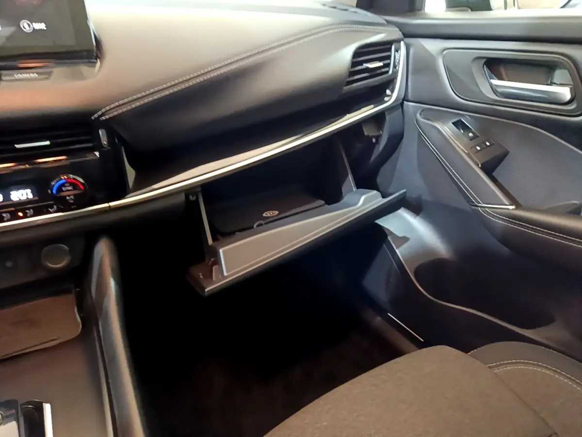 Intérieur du Nissan Qashqai e-Power 190 N-Connecta 2023, vue côté passager avec boîte à gants ouverte et détails en cuir noir.