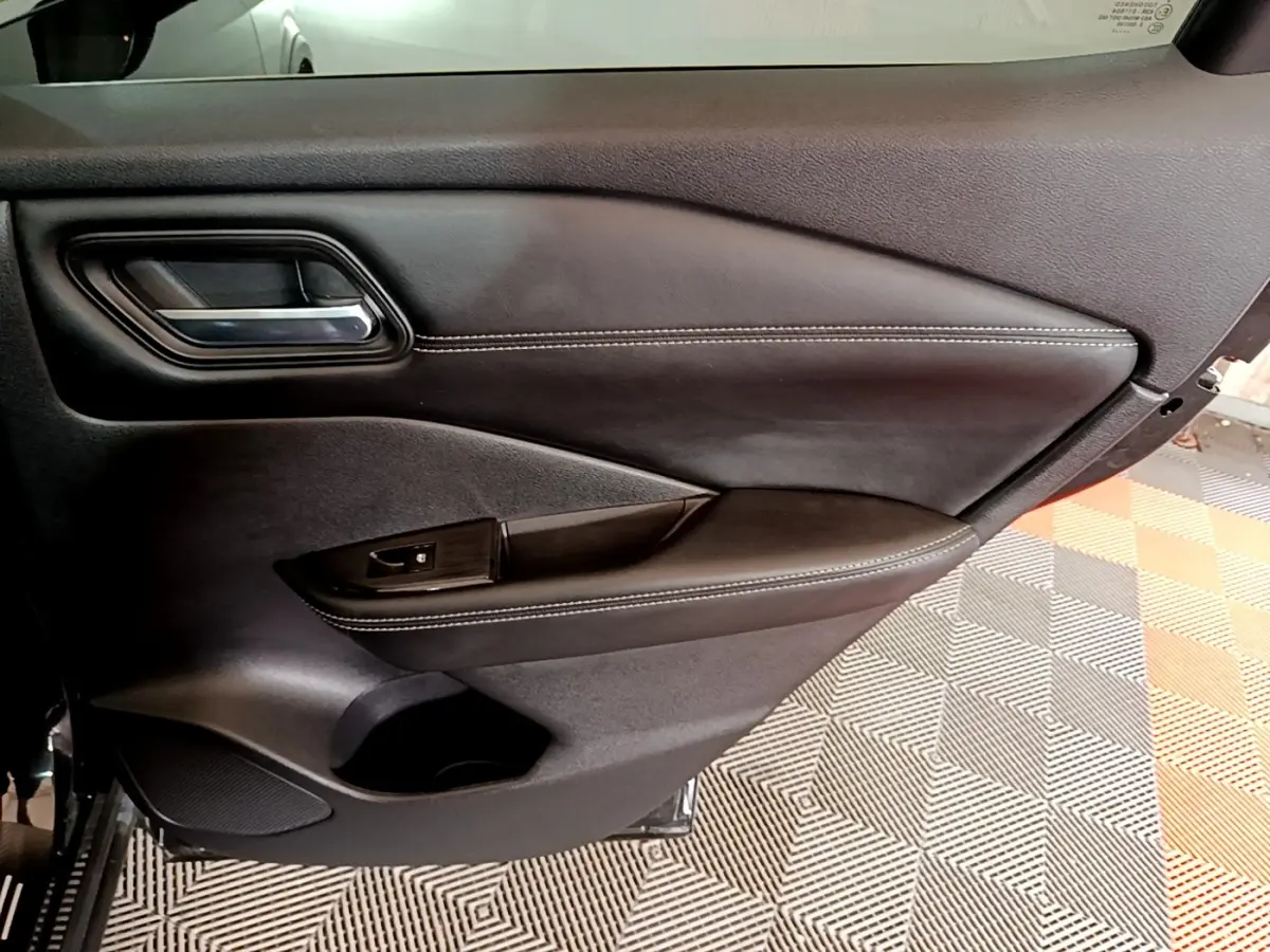 Vue rapprochée de la porte intérieure côté gauche noire du Nissan Qashqai e-Power 190 N-Connecta avec surpiqûres blanches.