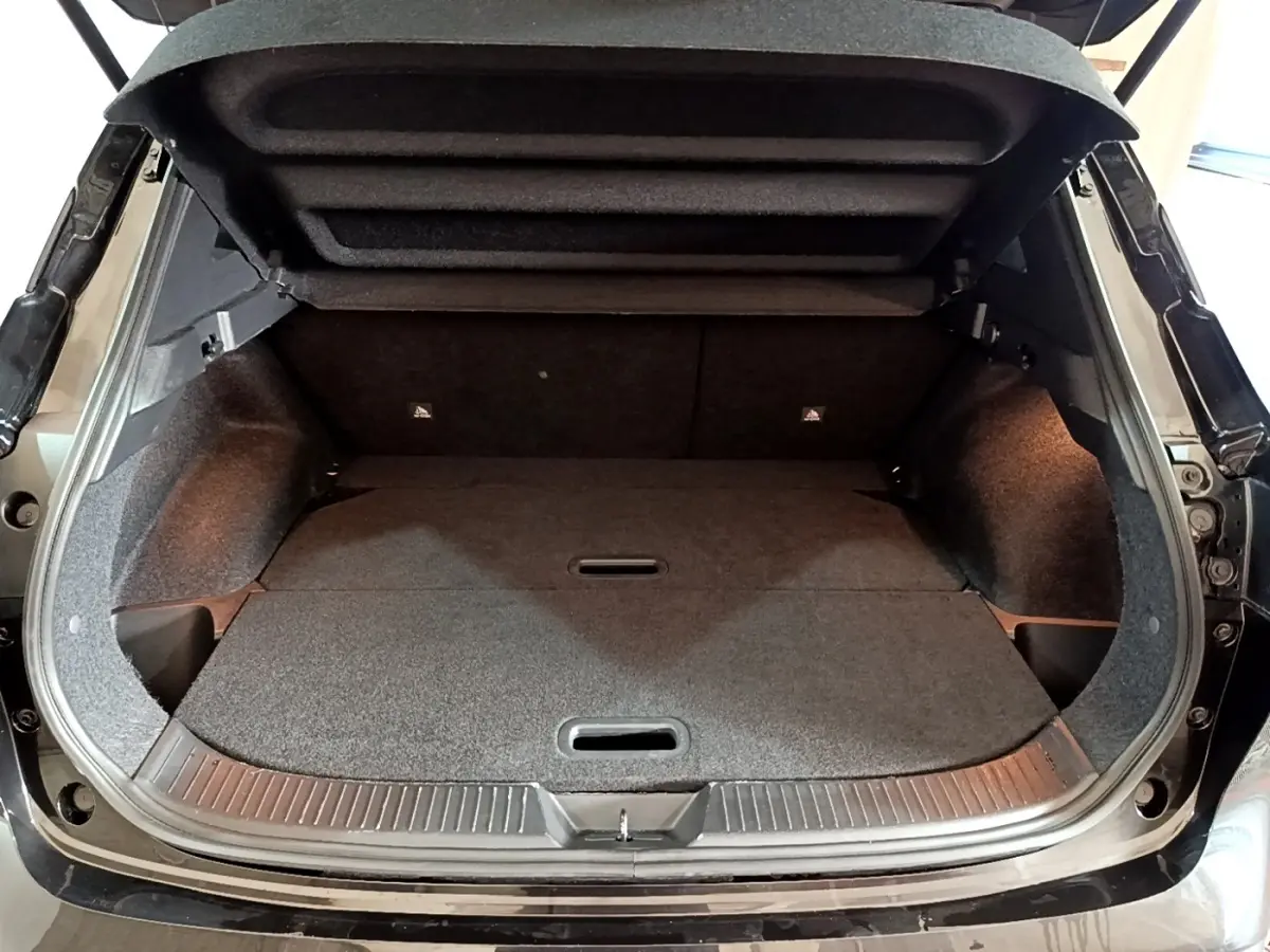 Coffre ouvert vu de l’arrière d’un Nissan Qashqai e-Power 190 N-Connecta noir avec banquette rabattue et intérieur sombre.