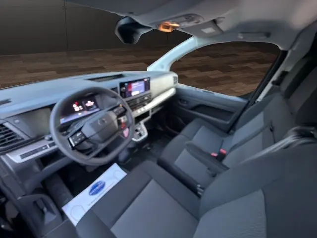 Vue intérieure du poste de conduite du Citroën Jumpy 2026, avec tableau de bord numérique et sièges gris foncé.