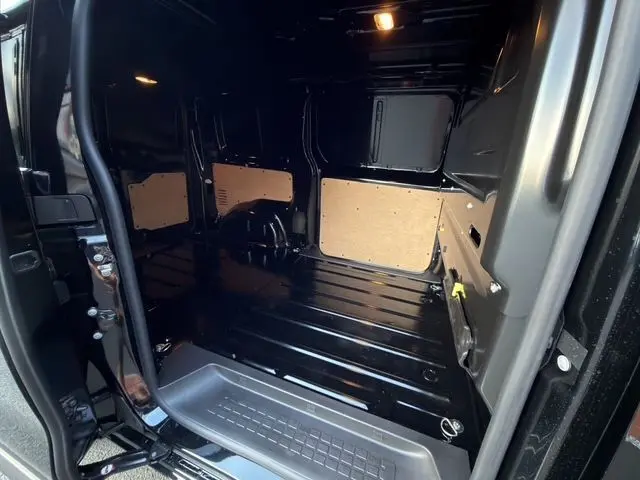 Vue intérieure du compartiment de chargement noir du Citroën Jumpy FG M 2.2 Diesel, avec porte latérale ouverte.