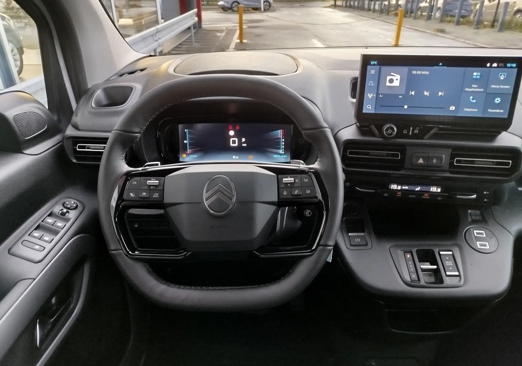 Vue intérieure centrée sur le volant et le tableau de bord numérique du Citroën Berlingo 2025, finition noire.