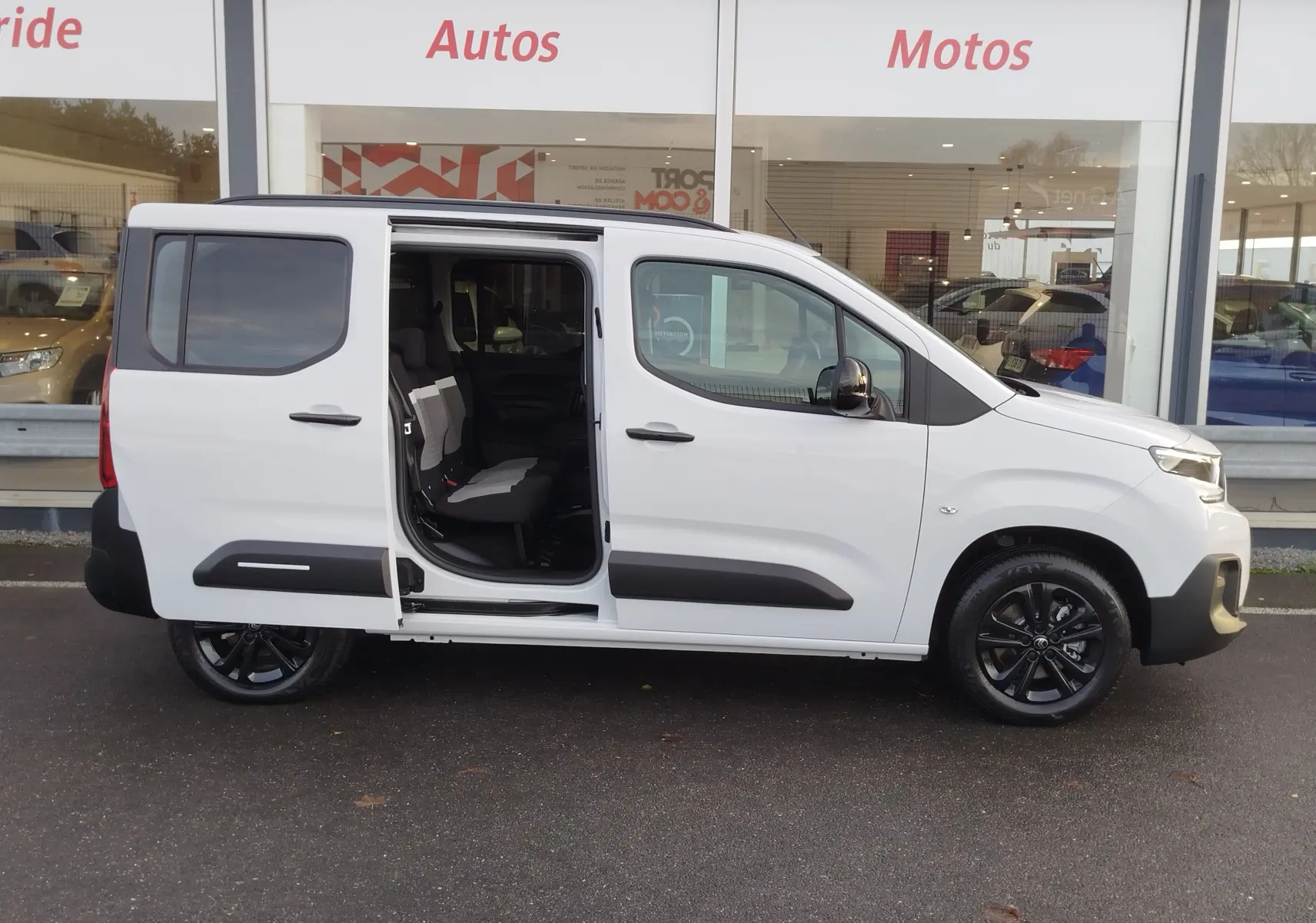 Vue de profil droit d'un Citroën Berlingo blanc Kaolin avec porte coulissante arrière ouverte, intérieur visible.