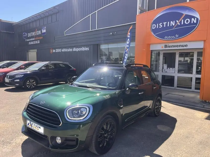 Vue 3/4 avant droite d'une MINI Countryman Cooper D 2018 en British Racing Green avec jantes noires devant un concessionnaire.