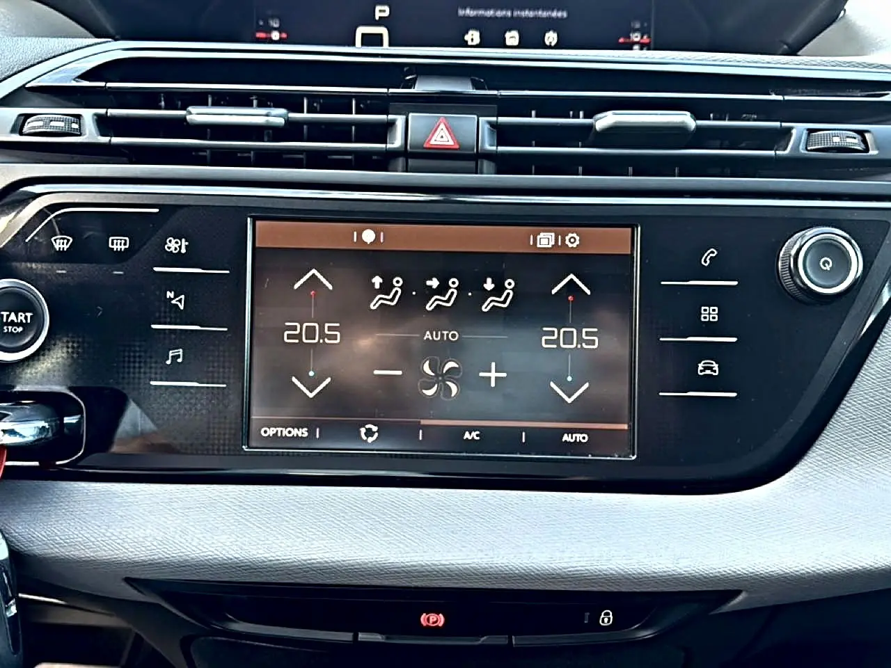 Vue rapprochée de la console centrale du Citroën Grand C4 Spacetourer gris alu, affichant l'écran tactile de climatisation bi-zone.