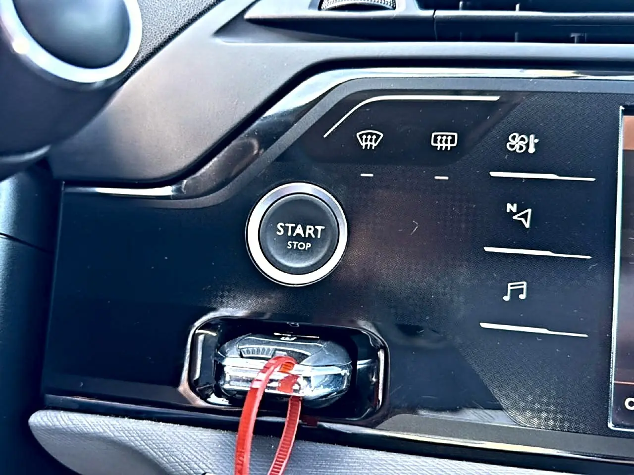Gros plan sur le bouton start/stop et la clé insérée dans la console centrale noire du Citroën Grand C4 Spacetourer gris alu.