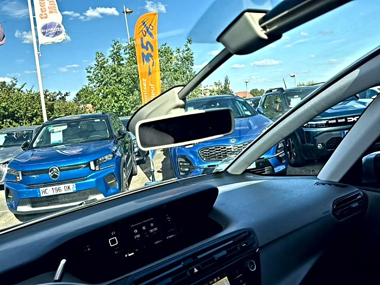 Vue intérieure côté conducteur du tableau de bord du Citroën Grand C4 SpaceTourer gris alu avec rétroviseur central visible.