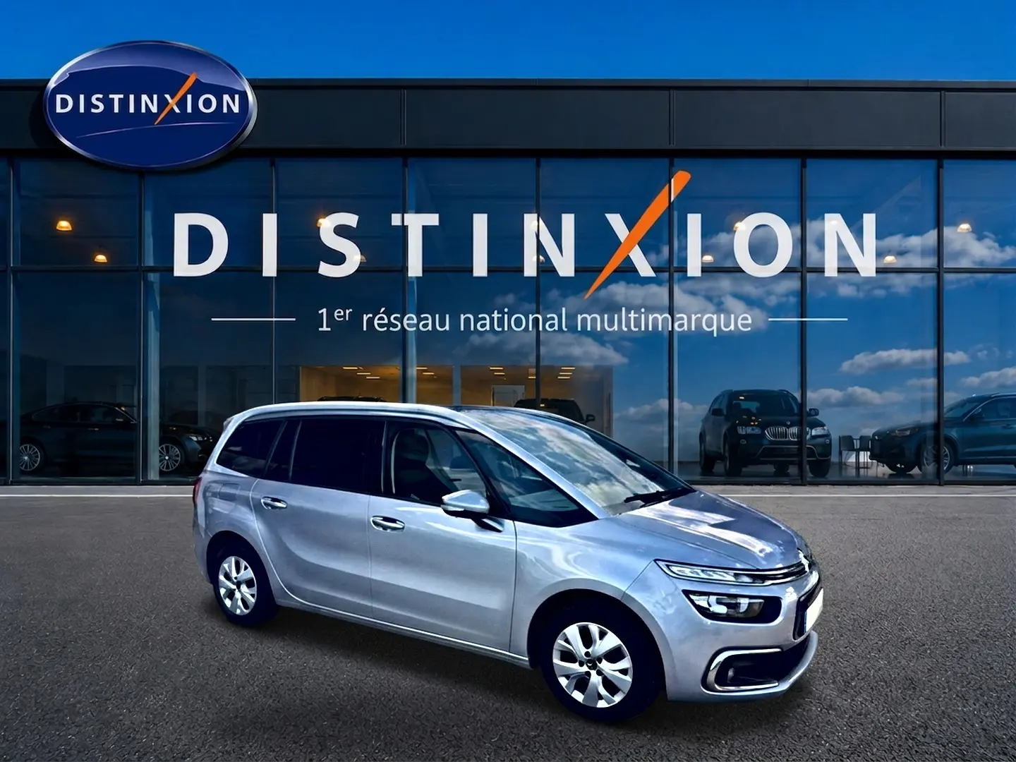 Citroën Grand C4 Spacetourer gris alu en 3/4 avant droit, avec jantes alu et vitres teintées, devant showroom Distinxion.