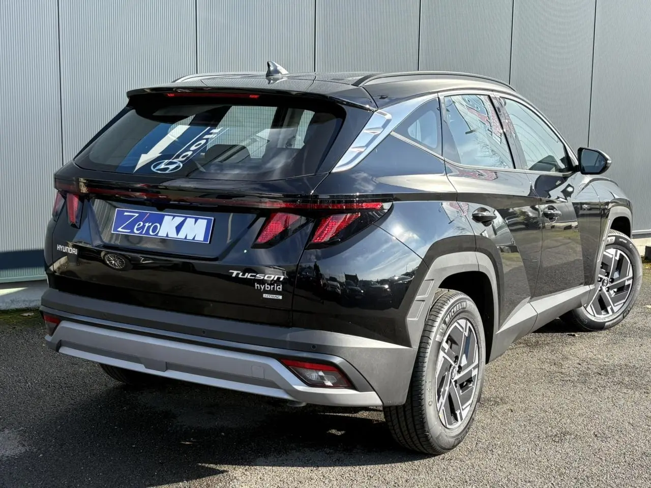 Vue 3/4 arrière droite d'un Hyundai Tucson hybride noir Abyss avec feux arrière LED et jantes alliage 17 pouces.