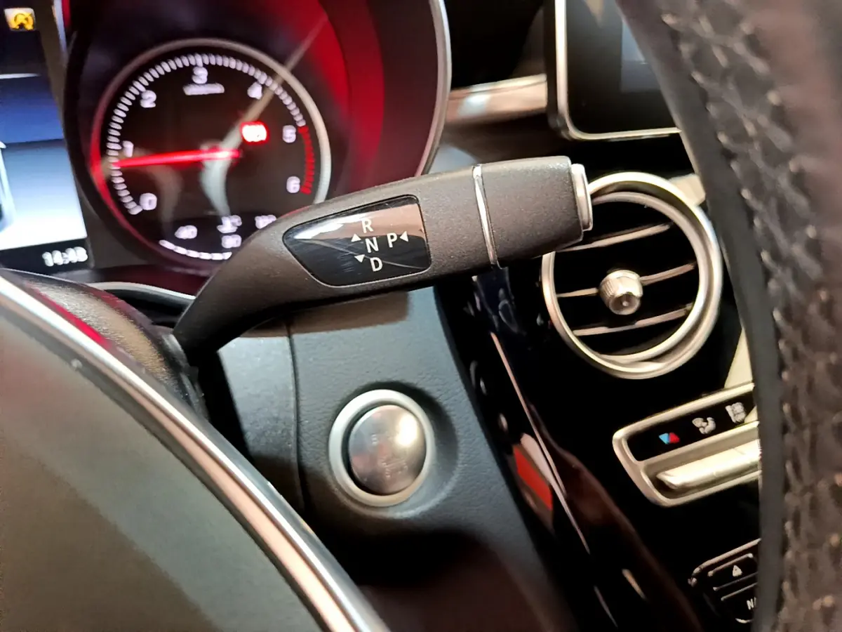 Gros plan sur la commande de boîte automatique à droite du volant dans l'habitacle noir d'une Mercedes Classe C Coupé 2018.