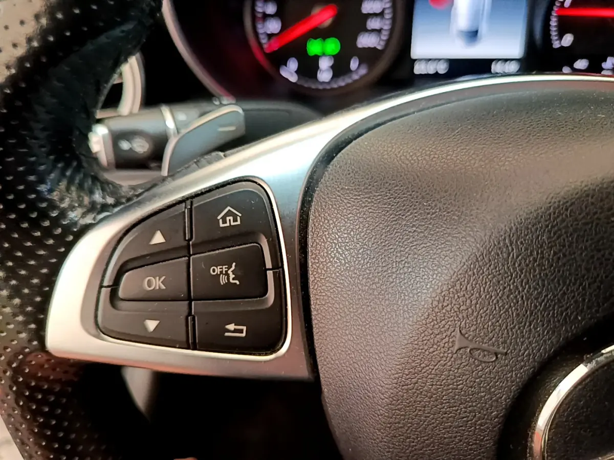 Gros plan sur les commandes gauche du volant en cuir noir du Mercedes Classe C Coupé C 220 d Fascination 2018.