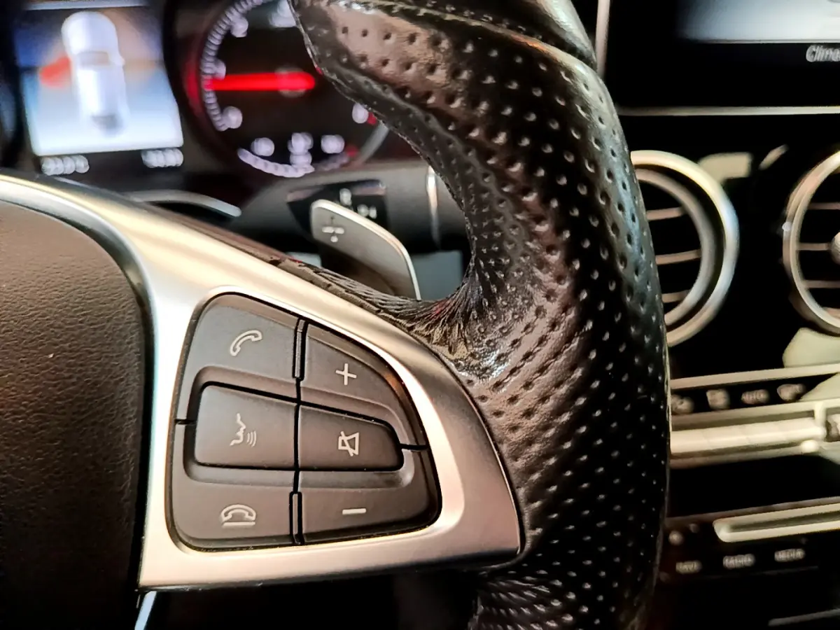 Gros plan sur les commandes du volant cuir perforé de la Mercedes Classe C Coupé C 220 d Fascination 2018.