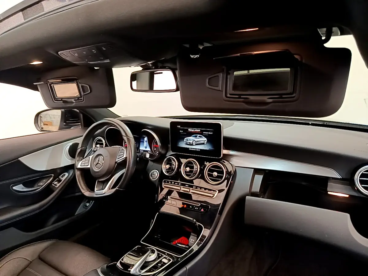 Intérieur noir de la Mercedes Classe C Coupé 2018, vue côté conducteur sur tableau de bord et écran central tactile.