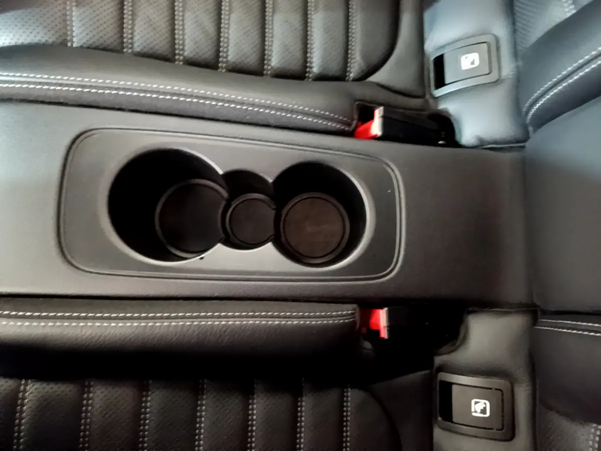 Gros plan sur la console centrale noire avec porte-gobelets et sièges en cuir noir du Mercedes Classe C Coupé C 220 d.