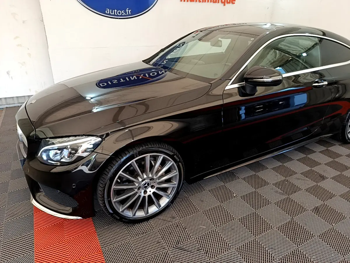 Mercedes Classe C Coupé noir vue 3/4 avant droit, mettant en valeur ses jantes alliage et ses phares LED élégants.