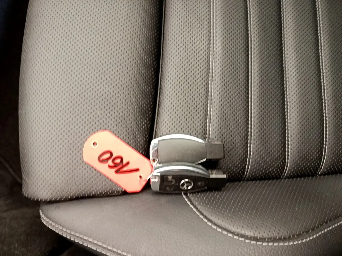 Gros plan sur la clé Mercedes posée sur la sellerie en cuir noir perforé de la Classe C Coupé C 220 d Fascination 2018.