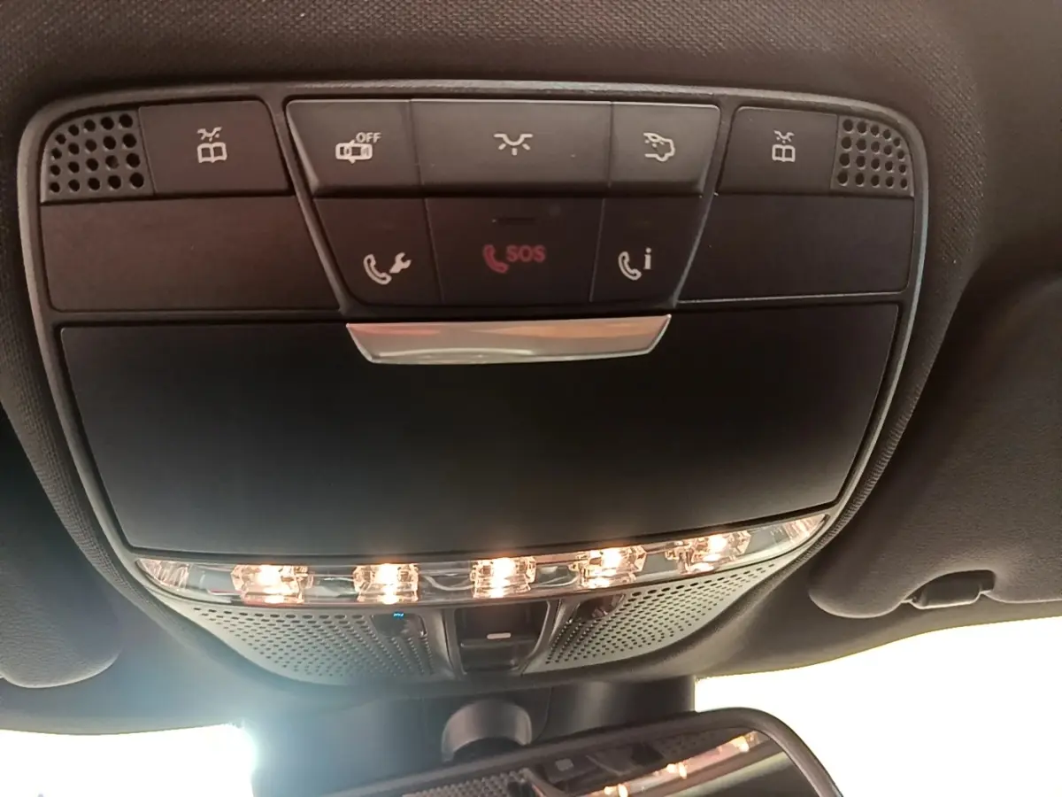 Vue en contre-plongée du panneau de commandes de plafonnier avec éclairage et boutons SOS dans l'habitacle de la Mercedes Classe C Coupé.