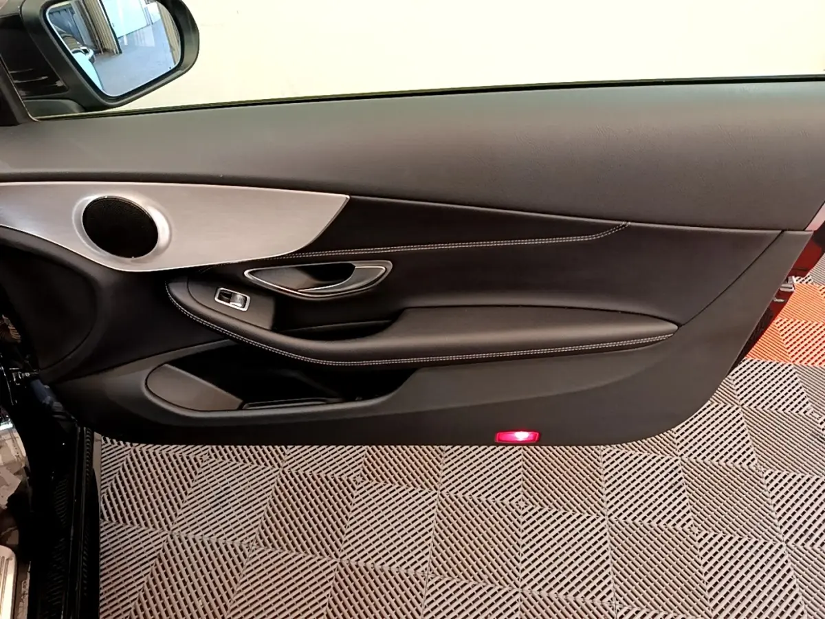 Intérieur montrant la porte côté gauche noire avec surpiqûres blanches et insert aluminium d'une Mercedes Classe C Coupé 2018.