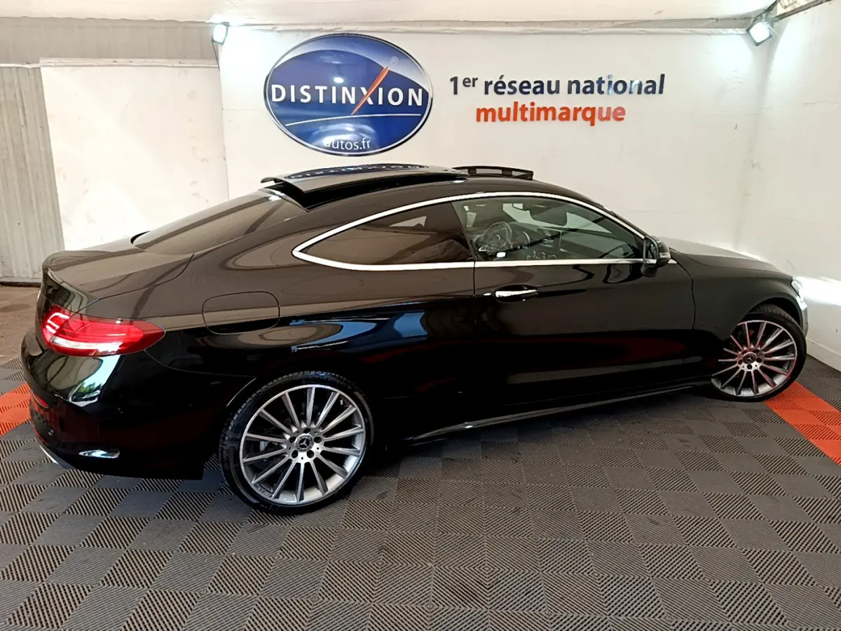 Vue latérale droite d'une Mercedes Classe C Coupé C 220 d Fascination noire avec toit ouvrant et jantes alliage multibranches.