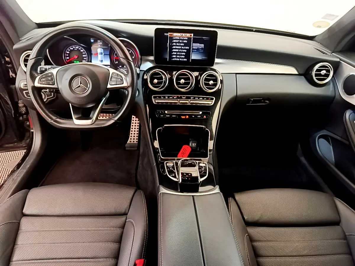 Intérieur noir de Mercedes Classe C Coupé 2018, vue frontale sur tableau de bord, volant cuir et écran central tactile.