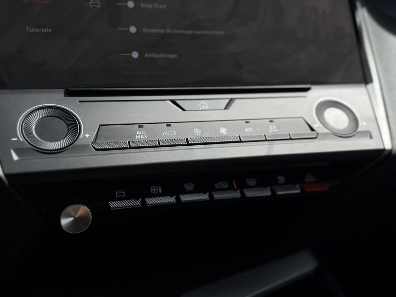 Détail du tableau de bord de la Peugeot 308 2025 gris Artense, montrant les commandes de climatisation tactile et boutons fonctionnels.