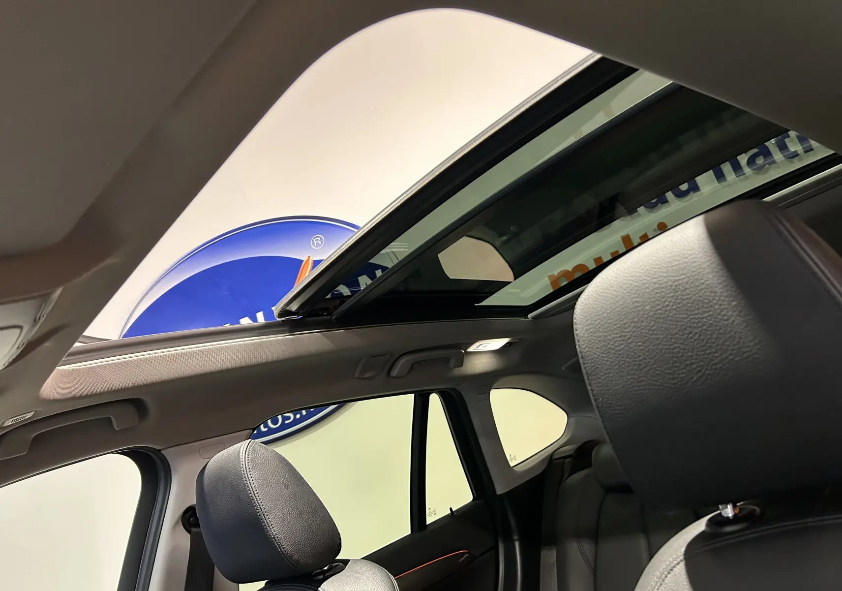 Vue intérieure du BMW X1 sDrive 18D 2019 argent métallisé, mettant en valeur le toit ouvrant panoramique et les sièges en cuir noir.