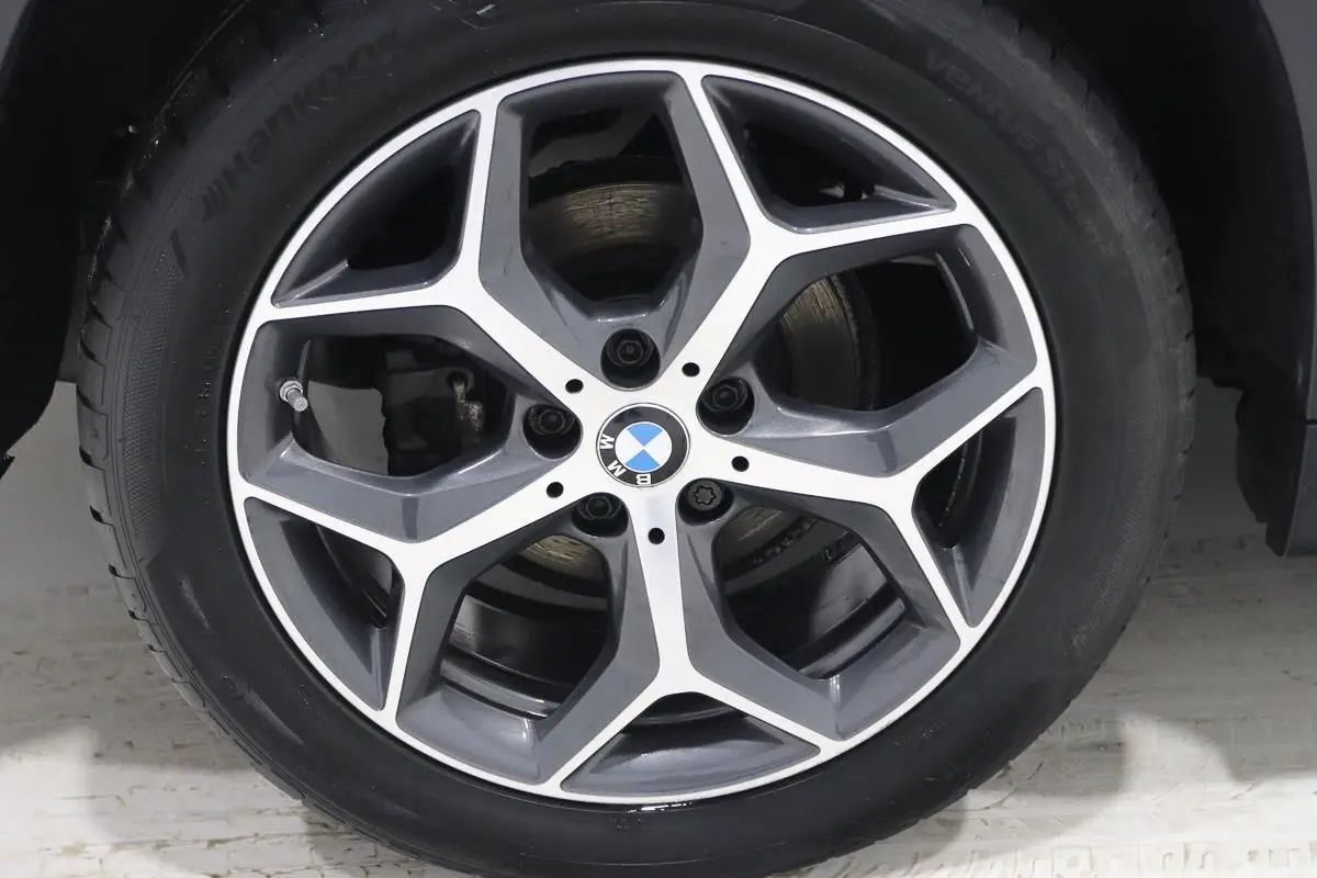 Gros plan sur la jante alliage bi-ton avec logo BMW au centre du BMW X1 sDRIVE 18D argent métallisé.