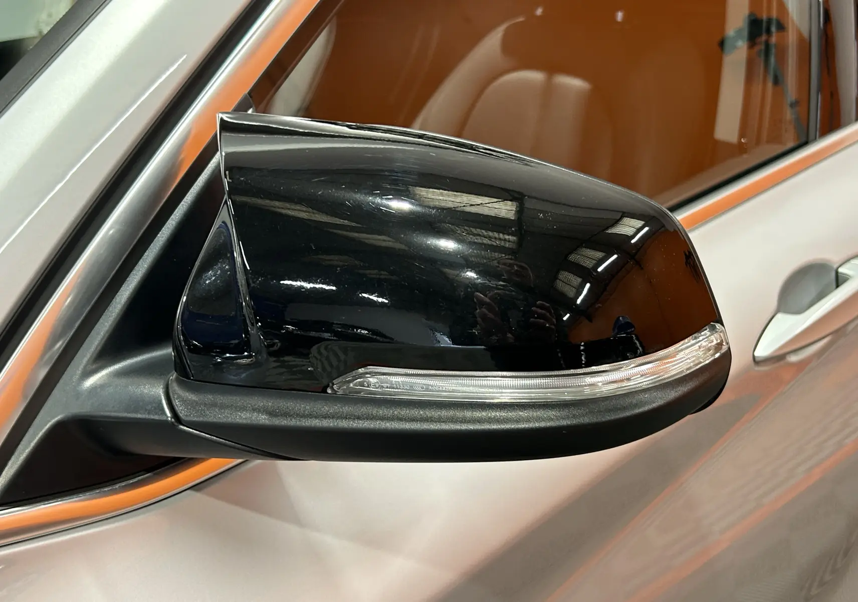 Gros plan sur le rétroviseur extérieur droit noir brillant d’un BMW X1 argent métallisé de 2019.