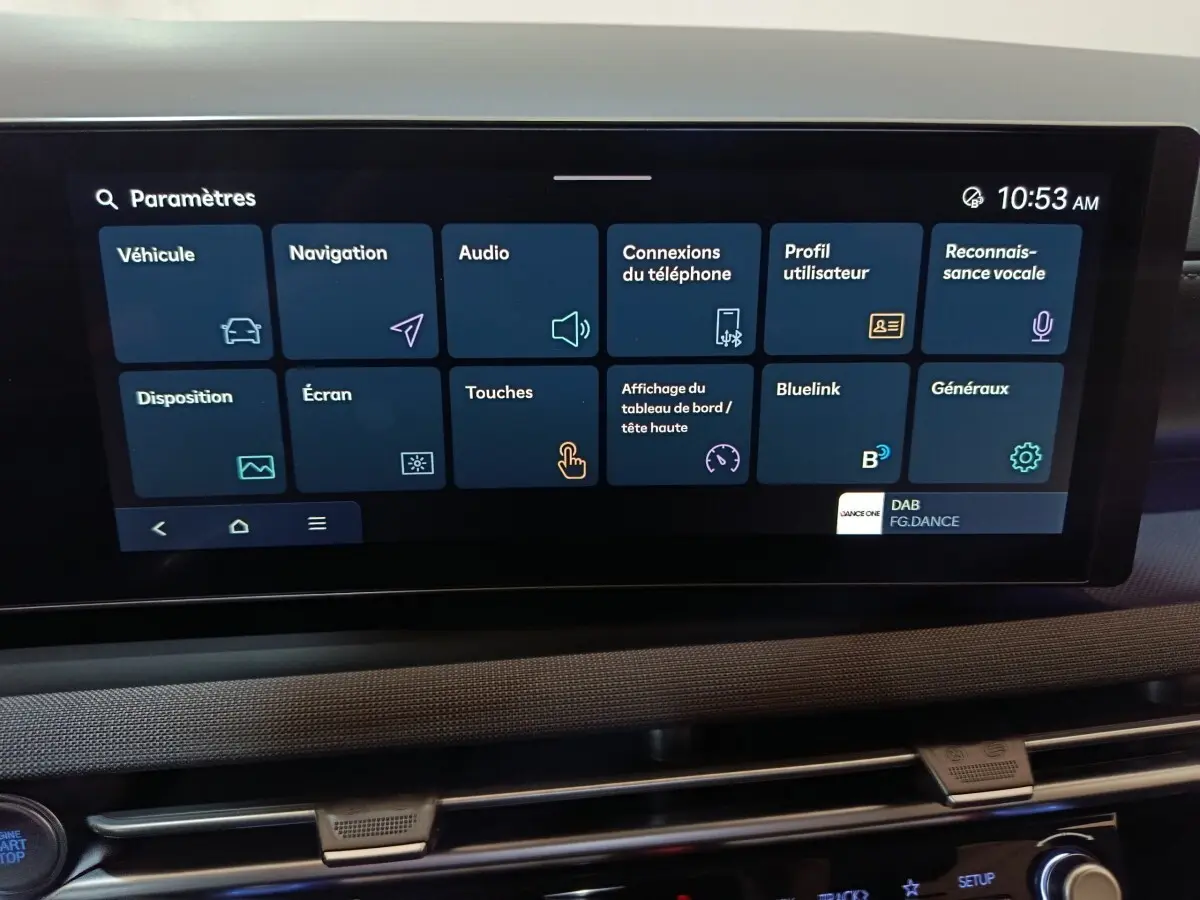 Écran tactile central affichant les paramètres du système multimédia du Hyundai Tucson gris clair, vue intérieure frontale.