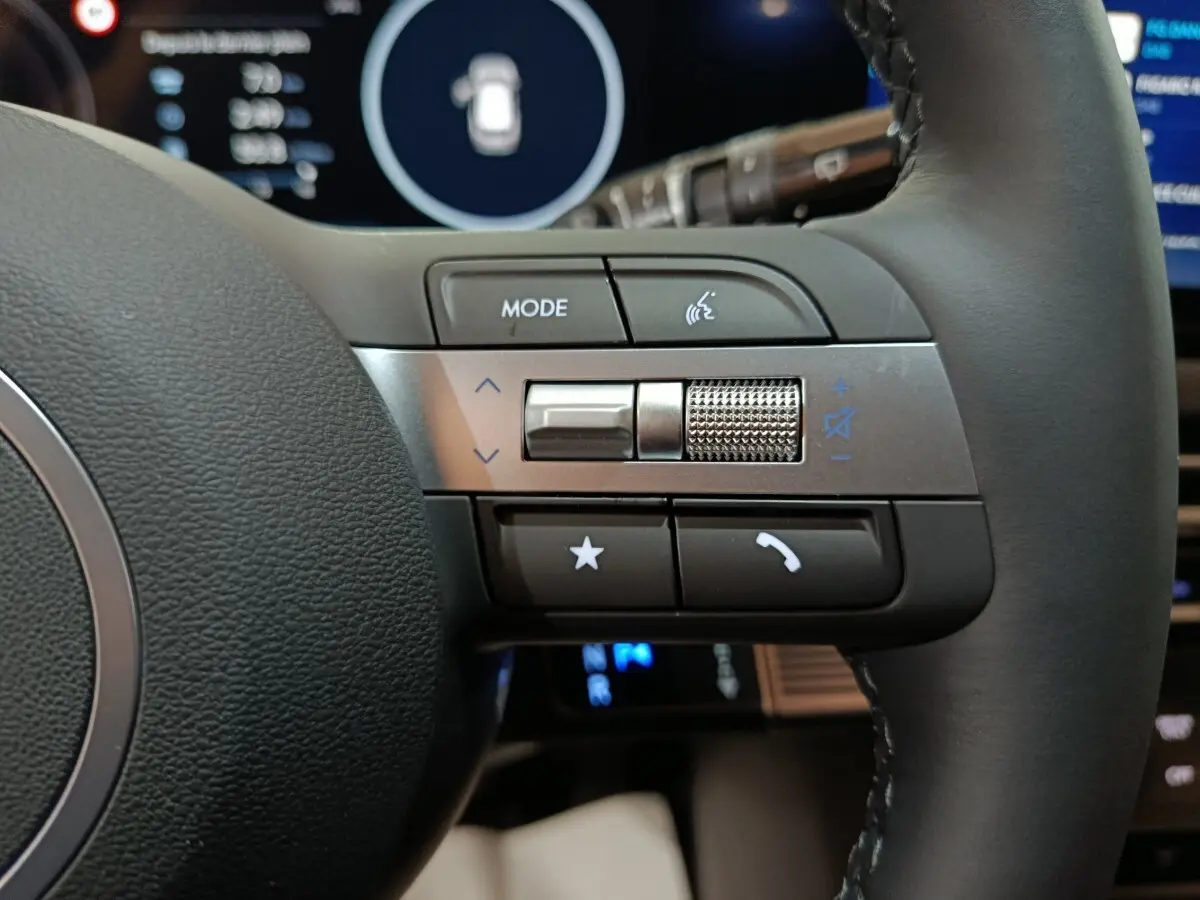 Gros plan sur les commandes multifonctions à droite du volant cuir noir du Hyundai Tucson gris clair 2025.