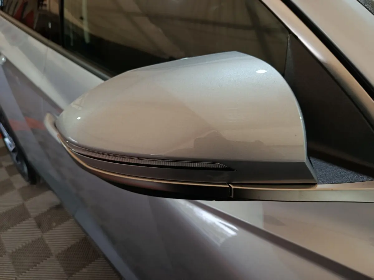 Gros plan sur le rétroviseur droit gris clair du Hyundai Tucson 2025 avec clignotant intégré.