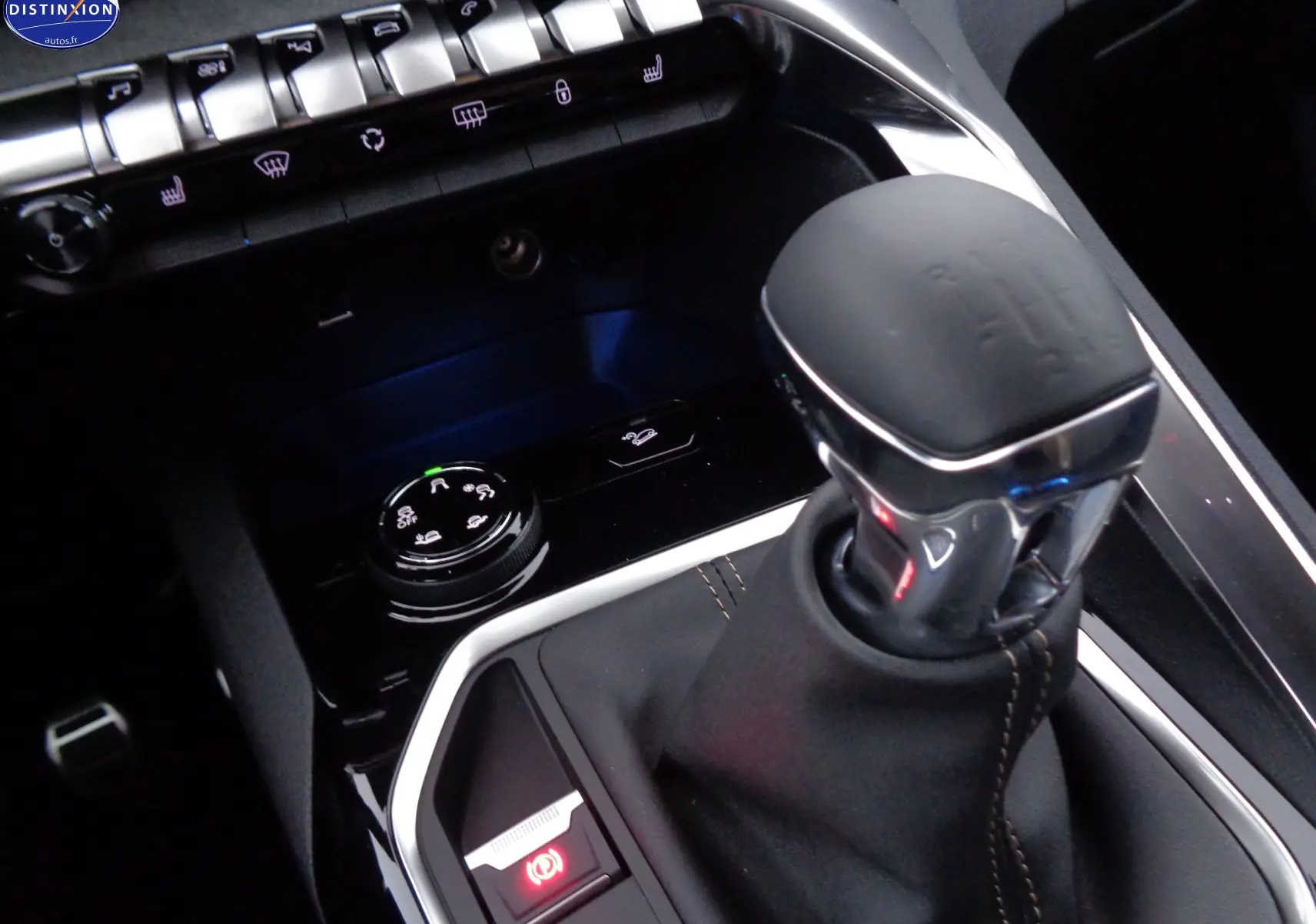 Gros plan sur le levier de vitesse manuel noir et les commandes centrales du Peugeot 3008 GT 2023 en intérieur sombre.