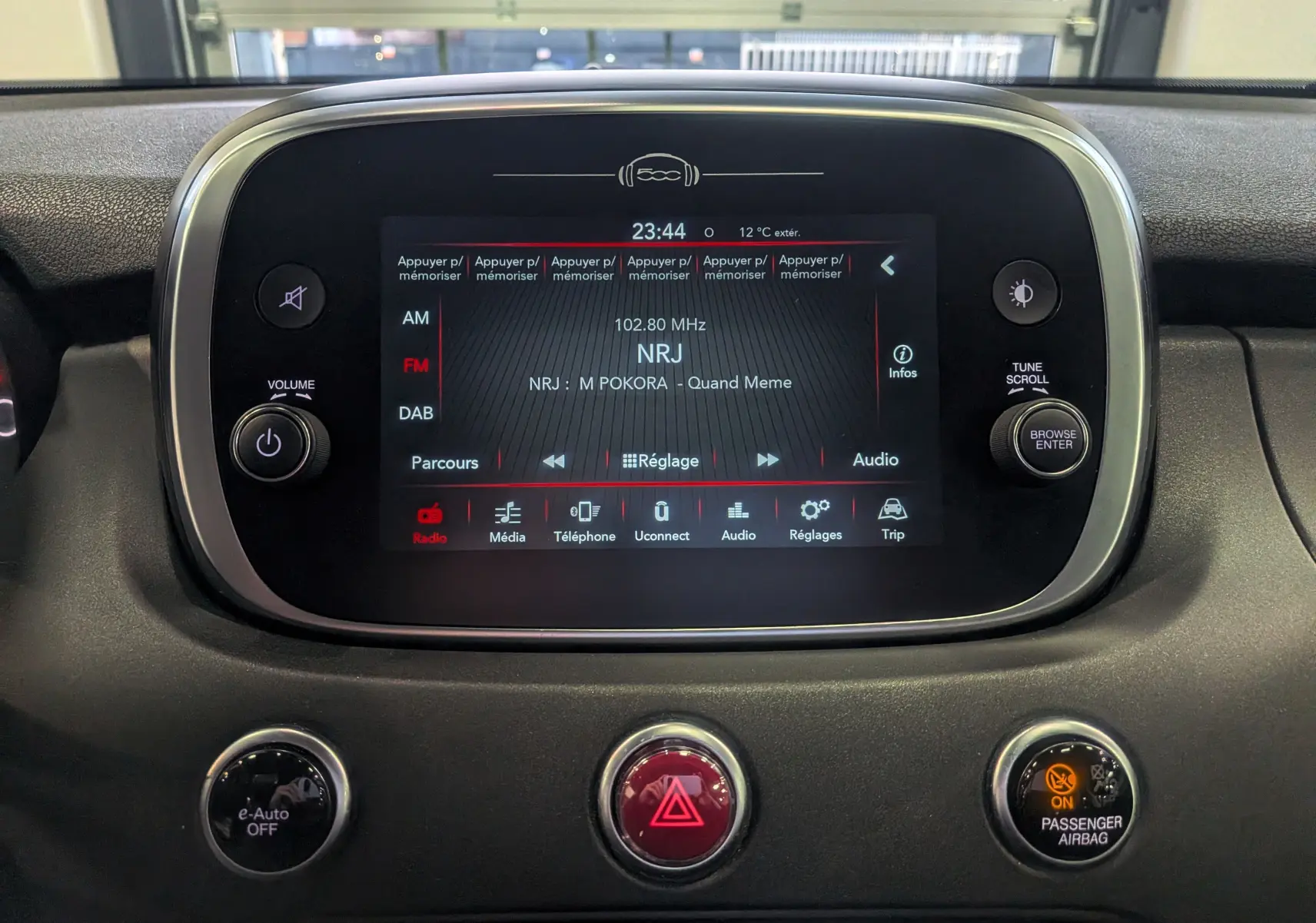 Vue rapprochée de l'écran tactile central du tableau de bord de la Fiat 500X 2024, affichant la radio NRJ.
