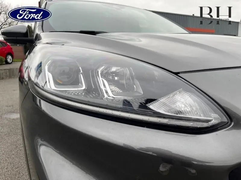 Gros plan sur le phare avant droit du Ford Kuga gris Magnetic métallisé, soulignant ses détails LED modernes.